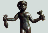 Statuette en bronze représentant Bacchus enfant tenant une grappe de raisin et un vase.Musée de l'Arles antique.