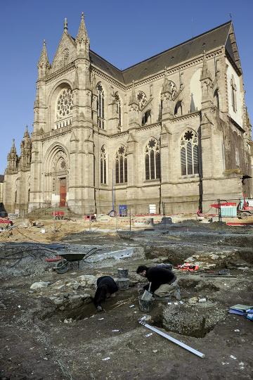 Vue du chantier de fouille, avec l’imposante église Notre-Dame-de-Bonne-Nouvelle en arrière-plan. 