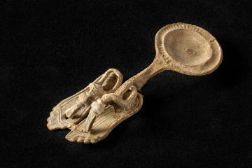 Miniature en plomb : paire de sandales savamment ornées accrochée à une patère (longueur :  environ : 9 cm).