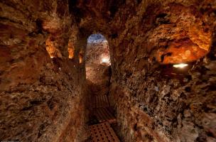 Vue d’ensemble du couloir menant à la salle principale d'un souterrain médiéval découvert à Sublaines (Indre-et-Loire), 2012.&nbsp;Quatre niches éclairent sa paroi. Au total, ce sont vingt niches destinées à abriter des lampes à huile qui ont été recensée